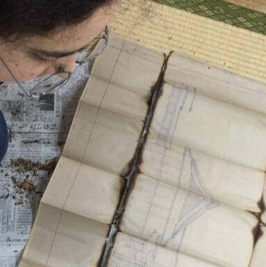A photo of a person looking at blueprints of a shrine