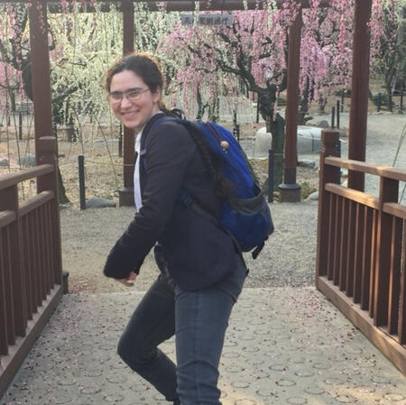 A person in a suit jacket, sidling toward the camera