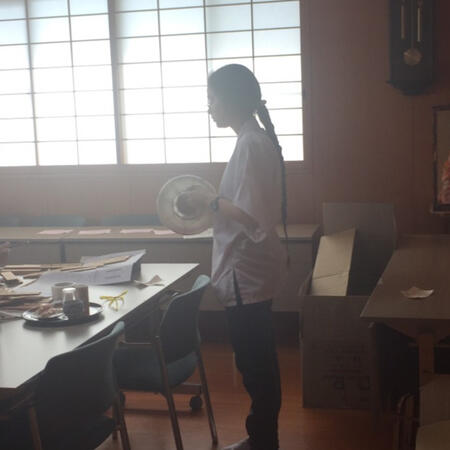 A person in silhouette, holding a paper lantern.